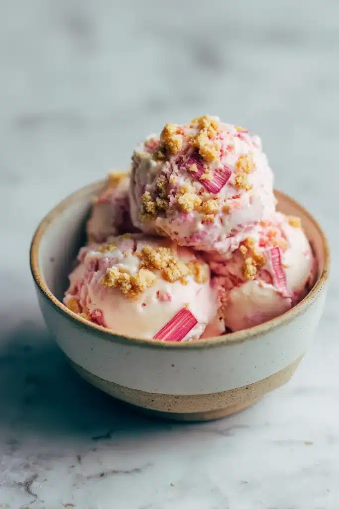Rhubarb Crumble Ice Cream scoops with crumble topping in pink bowl