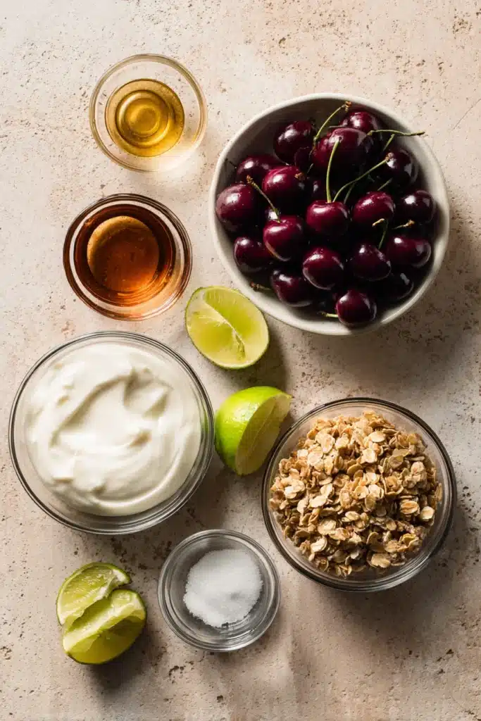 Ingredients for roasted cherry yogurt bowl with cherries, yogurt, granola, honey, and lime