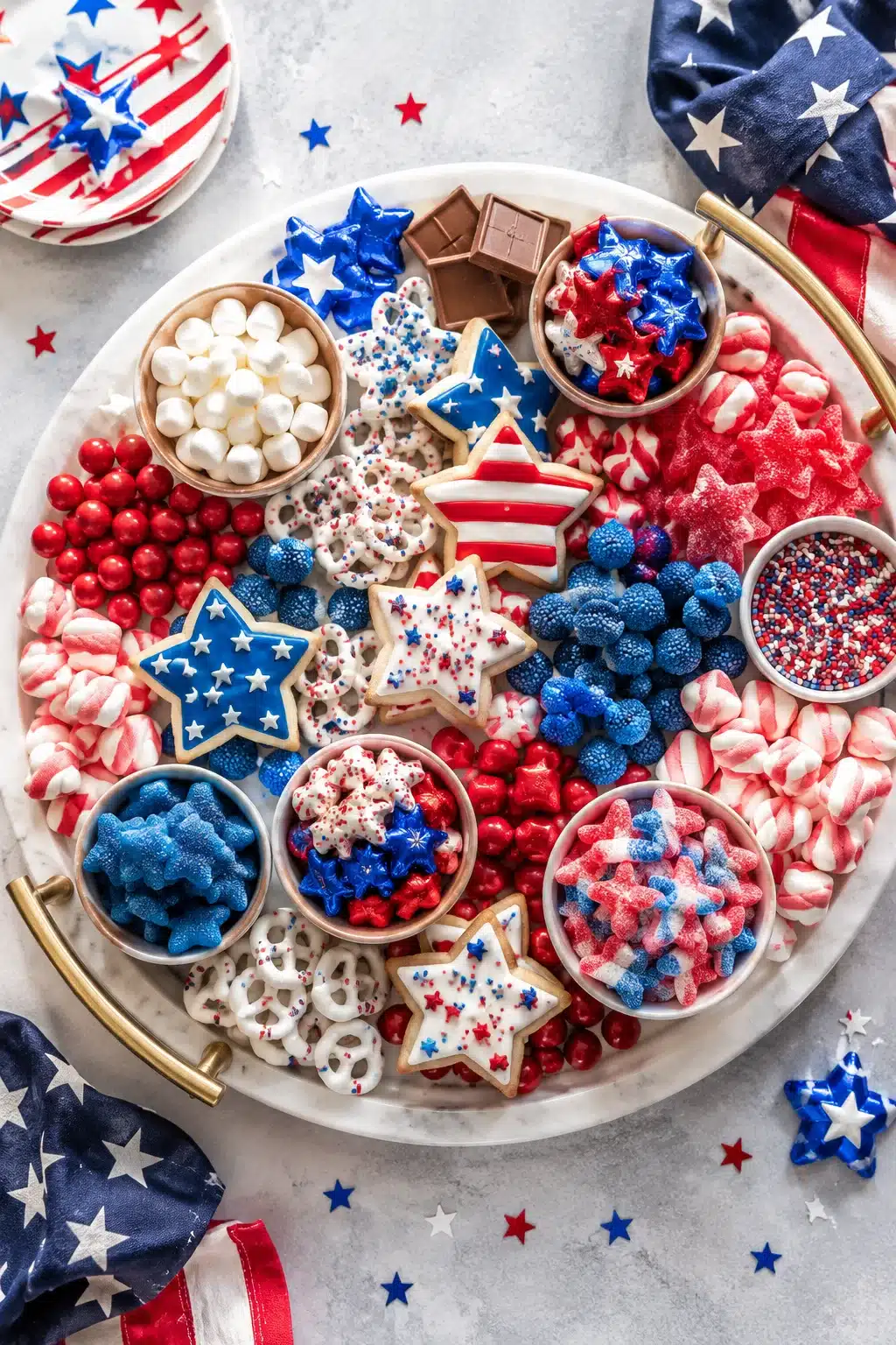 4th of July charcuterie board with red white and blue candies and decorated cookies