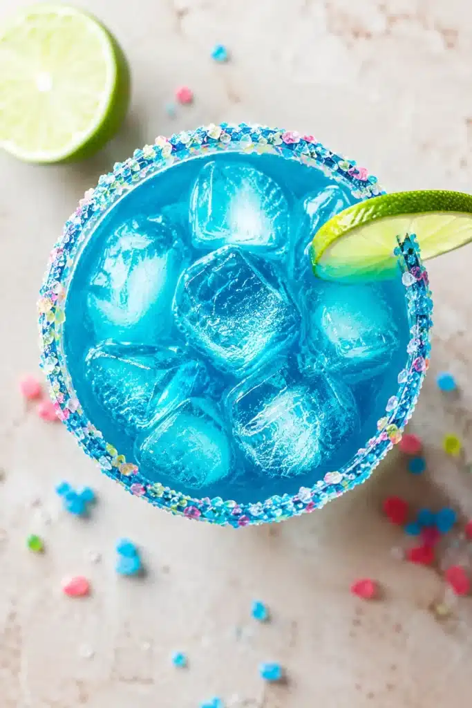Top view of Firecracker Margarita with blue drink and red candy rim